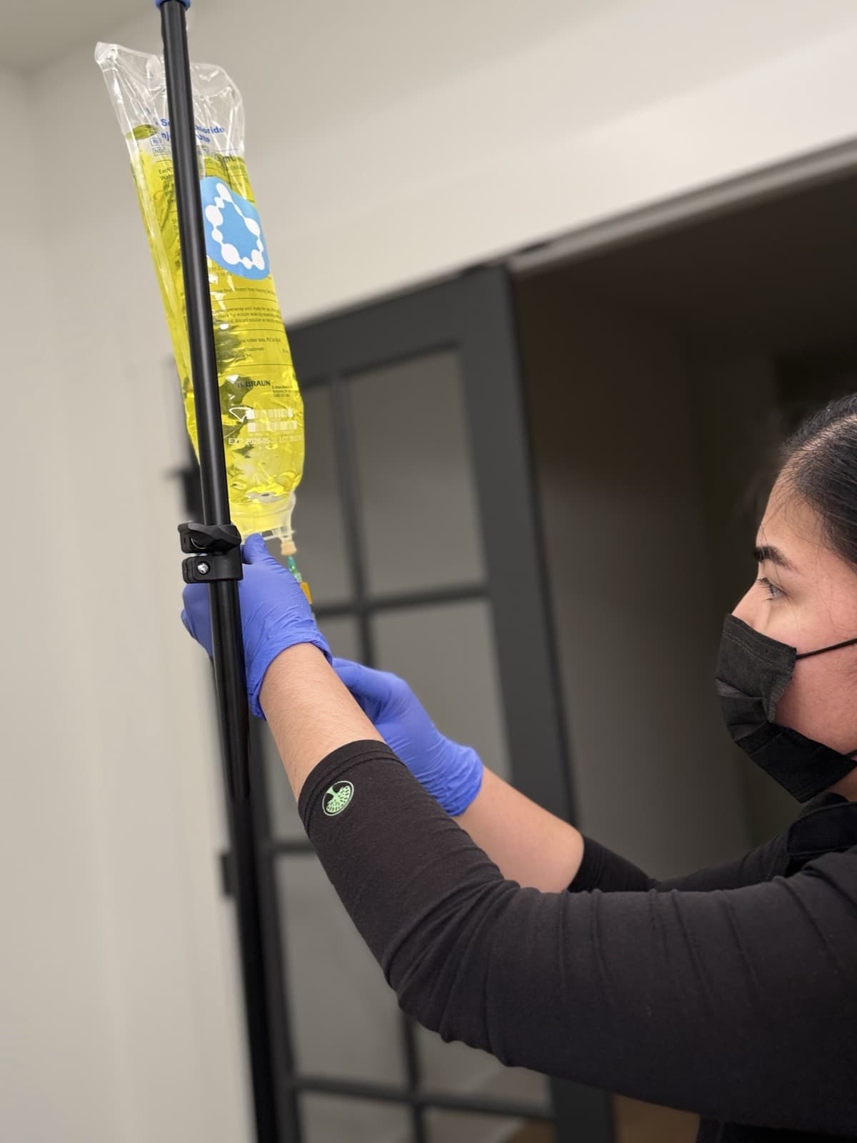 A licensed nurse hanging an IV bag before a home visit